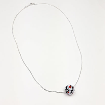 Schwarz-weiße Wirbel mit roten Akzenten - Glasperle auf Silberkette